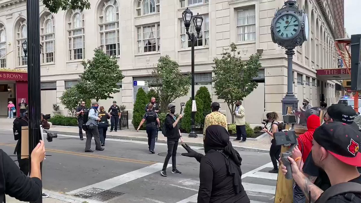 Some protesters pulling others away from the policemen